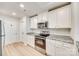 Well-lit kitchen featuring white cabinets, stainless steel appliances, granite counters, and wood-look floors at 908 Morien St, Richburg, SC 29729