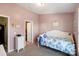 A cozy bedroom features light pink walls and a charming bed with a floral comforter at 915 Tj Dr, Monroe, NC 28112