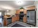 Well-lit kitchen featuring stainless steel appliances, wooden cabinetry, and granite countertops at 915 Tj Dr, Monroe, NC 28112