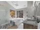 Bright bathroom with a large soaking tub, double vanity, and a large window with nature views at 9334 Hunting Ct, Matthews, NC 28105