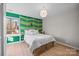 Stylish bedroom with a king bed, a funky green accent wall, and an abundance of natural light at 9334 Hunting Ct, Matthews, NC 28105