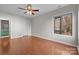 Spacious bedroom with hardwood floors, ceiling fan, and view of the trees at 9334 Hunting Ct, Matthews, NC 28105