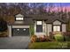 Charming gray brick home with a two-car garage, black trim, mature landscaping and well-maintained lawn at 9334 Hunting Ct, Matthews, NC 28105