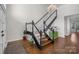 Inviting home foyer featuring hardwood floors, staircase with black railing, and chandelier lighting at 9334 Hunting Ct, Matthews, NC 28105