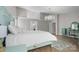 Bright bedroom showcases an ornate aqua-colored bed, a crystal chandelier, and herringbone-patterned wood flooring at 9334 Hunting Ct, Matthews, NC 28105