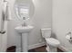 Powder room featuring a pedestal sink, white toilet and decorative oval mirror at 9611 Rayneridge Dr, Huntersville, NC 28078