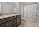 Bathroom featuring double sinks, granite counters, dark wood cabinets and a shower with patterned curtain at 9611 Rayneridge Dr, Huntersville, NC 28078