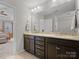 Bathroom with a double vanity featuring granite countertops and a large mirror with vanity lighting at 9611 Rayneridge Dr, Huntersville, NC 28078