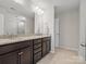 Bathroom with a double vanity featuring granite countertops and a large mirror with vanity lighting at 9611 Rayneridge Dr, Huntersville, NC 28078