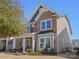 Two-story home with stone and siding, featuring a covered front porch and manicured lawn at 9611 Rayneridge Dr, Huntersville, NC 28078