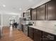 Well-lit kitchen with stainless steel appliances and dark wood cabinetry; open to dining area at 9611 Rayneridge Dr, Huntersville, NC 28078