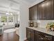 Galley kitchen with dark wood cabinets and granite countertops; open to living area at 9611 Rayneridge Dr, Huntersville, NC 28078