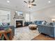 Inviting living room with a fireplace, plush blue seating, and a stylish ceiling fan at 9611 Rayneridge Dr, Huntersville, NC 28078