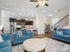 Open-concept space with hardwood floors, blue sofas, and views of the kitchen at 9611 Rayneridge Dr, Huntersville, NC 28078