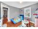 Bright bedroom with a blue racecar bed, windows, and a hardwood floor at 1001 E 8Th Ave, Gastonia, NC 28054