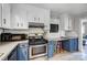 Updated kitchen with white cabinets, stainless steel appliances, a built-in desk area, and tiled floors at 1001 E 8Th Ave, Gastonia, NC 28054