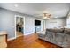Open living room with hardwood floors, a ceiling fan, and a view into the updated kitchen at 1001 E 8Th Ave, Gastonia, NC 28054