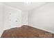 Bedroom with hardwood floors, two white doors, a recessed light, and two electrical outlets at 110 Wesser St, Davidson, NC 28036