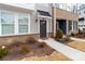 Close up of the home's exterior entrance featuring neutral siding, dark brick, and minimal plantings at 110 Wesser St, Davidson, NC 28036