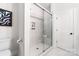 Walk-in shower featuring a glass enclosure with a built-in shelving unit and stylish floor tiles at 110 Wesser St, Davidson, NC 28036