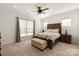 Comfortable bedroom with a ceiling fan, neutral carpet and furnishings, and large windows at 11031 Larkslea Ln, Charlotte, NC 28278