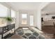 Bright entryway and living room with a modern rug, cabinet, and open floorplan at 11031 Larkslea Ln, Charlotte, NC 28278