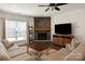 Cozy living room with a stone fireplace, window, and television on a media console at 11031 Larkslea Ln, Charlotte, NC 28278