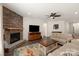 Living room with a stone fireplace, dark floors, and a mounted television at 11031 Larkslea Ln, Charlotte, NC 28278