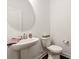 Elegant powder room featuring a modern pedestal sink and a decorative mirror at 11031 Larkslea Ln, Charlotte, NC 28278