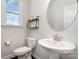 Charming powder room includes pedestal sink, round mirror, modern light fixtures, and decorative shelving at 11537 Red Rust Ln, Charlotte, NC 28277