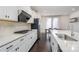 Modern kitchen features white cabinets, stainless steel appliances, quartz countertops, and dark wood floors at 11537 Red Rust Ln, Charlotte, NC 28277