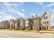 Well-maintained townhomes line a street with mature trees, sidewalks and manicured landscaping at 11537 Red Rust Ln, Charlotte, NC 28277