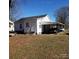 View of the rear of a white home with carport, wooden steps and yard at 116 Nella St, Chester, SC 29706