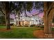 Spacious backyard featuring a covered patio, lush landscaping, and charming outdoor lighting at 124 Wellcraft Ct, Mooresville, NC 28117