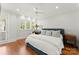 Comfortable bedroom with hardwood floors, ceiling fan, and a bright window with a view of the trees at 124 Wellcraft Ct, Mooresville, NC 28117