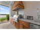 Well-equipped outdoor kitchen with stainless steel grill, tile backsplash, and scenic lake views at 124 Wellcraft Ct, Mooresville, NC 28117