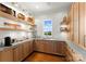 This well-organized pantry features custom wood cabinetry, open shelving, and a window with a scenic view at 124 Wellcraft Ct, Mooresville, NC 28117