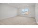 A brightly lit bedroom with carpet and a large window showing a neighborhood view at 1279 Kindness Nw Ct, Concord, NC 28027