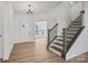 Bright foyer with light hardwood floors, a staircase and a view into a sunlit room beyond a doorway at 1279 Kindness Nw Ct, Concord, NC 28027