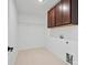 Brightly lit laundry room with tile floors, cabinets and wire shelving at 1279 Kindness Nw Ct, Concord, NC 28027