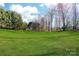 Expansive green backyard with mature trees, perfect for outdoor activities at 12860 Westmoreland Farm Rd, Davidson, NC 28036