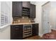 Stylish bar area with custom cabinets, wine storage, and countertop space for entertaining guests at 12860 Westmoreland Farm Rd, Davidson, NC 28036