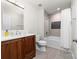 Well-lit bathroom featuring a wood vanity, a stylish shower with decorative tile, and modern fixtures at 12860 Westmoreland Farm Rd, Davidson, NC 28036