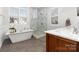 Elegant bathroom with a soaking tub, glass-enclosed shower, and modern fixtures at 12860 Westmoreland Farm Rd, Davidson, NC 28036