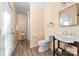Bright bathroom featuring wood tile flooring, a toilet, and a white sink at 12860 Westmoreland Farm Rd, Davidson, NC 28036