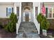Elegant front entrance with stone steps, lush greenery, and decorative pillars at 12860 Westmoreland Farm Rd, Davidson, NC 28036