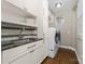 Bright laundry room featuring a sleek countertop, stainless steel sink, and modern washer and dryer units at 12860 Westmoreland Farm Rd, Davidson, NC 28036