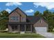 Handsome two-story brick home with a covered porch, attached two car garage, and professionally landscaped front yard at 13130 Macon Hall Dr, Mint Hill, NC 28227