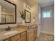 Bright bathroom with double vanity, granite countertops, framed mirrors, and tan tile flooring at 1538 Riverwalk Pkwy, Rock Hill, SC 29730