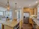 Open-concept kitchen with stainless steel appliances, granite island, view to living room and natural light at 1538 Riverwalk Pkwy, Rock Hill, SC 29730